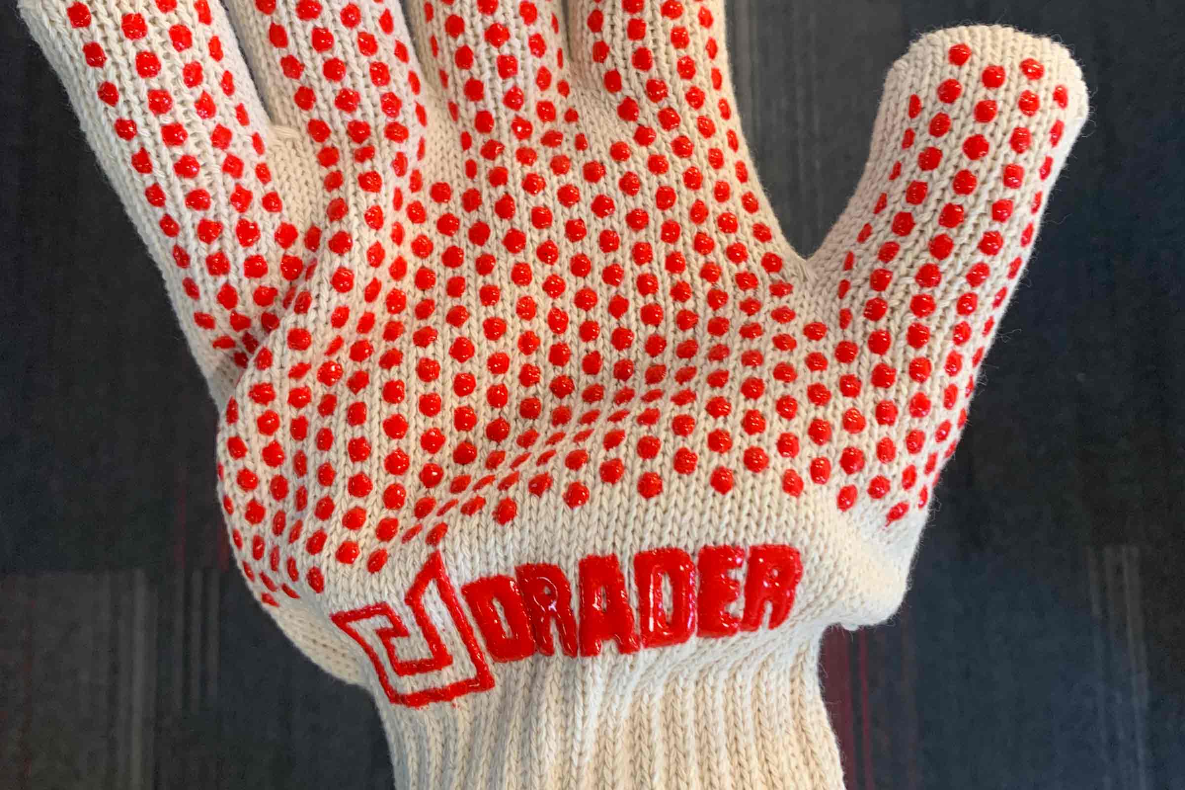 A worker uses an industrial heat sealer to join seams on a vinyl product at a manufacturing facility for industrial containers.